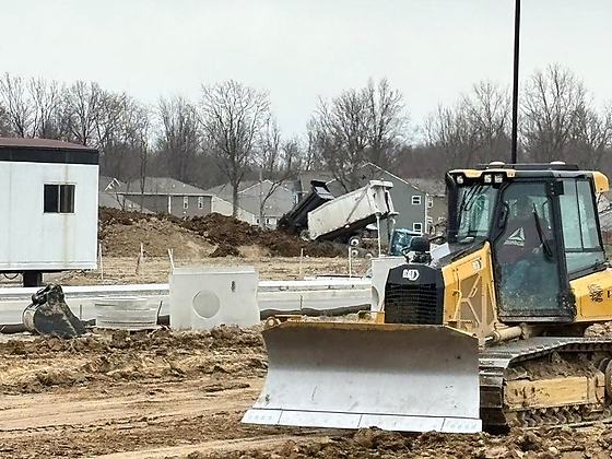BDX dozer blade working finish grade beside staged precast structures