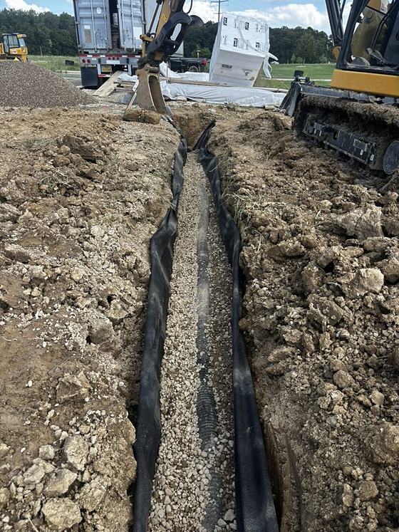 Perforated subdrain pipe installed in a stone-bedded trench by BDX