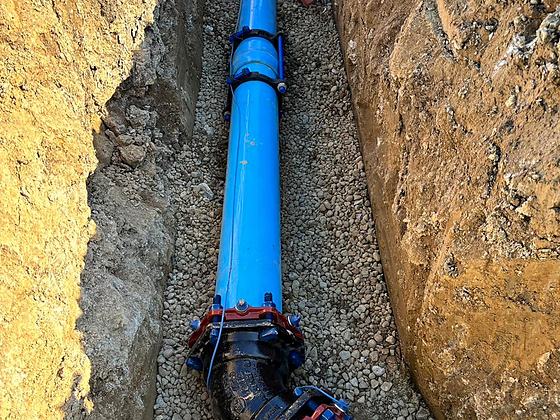 Blue ductile iron water main with a restrained joint bedded in stone