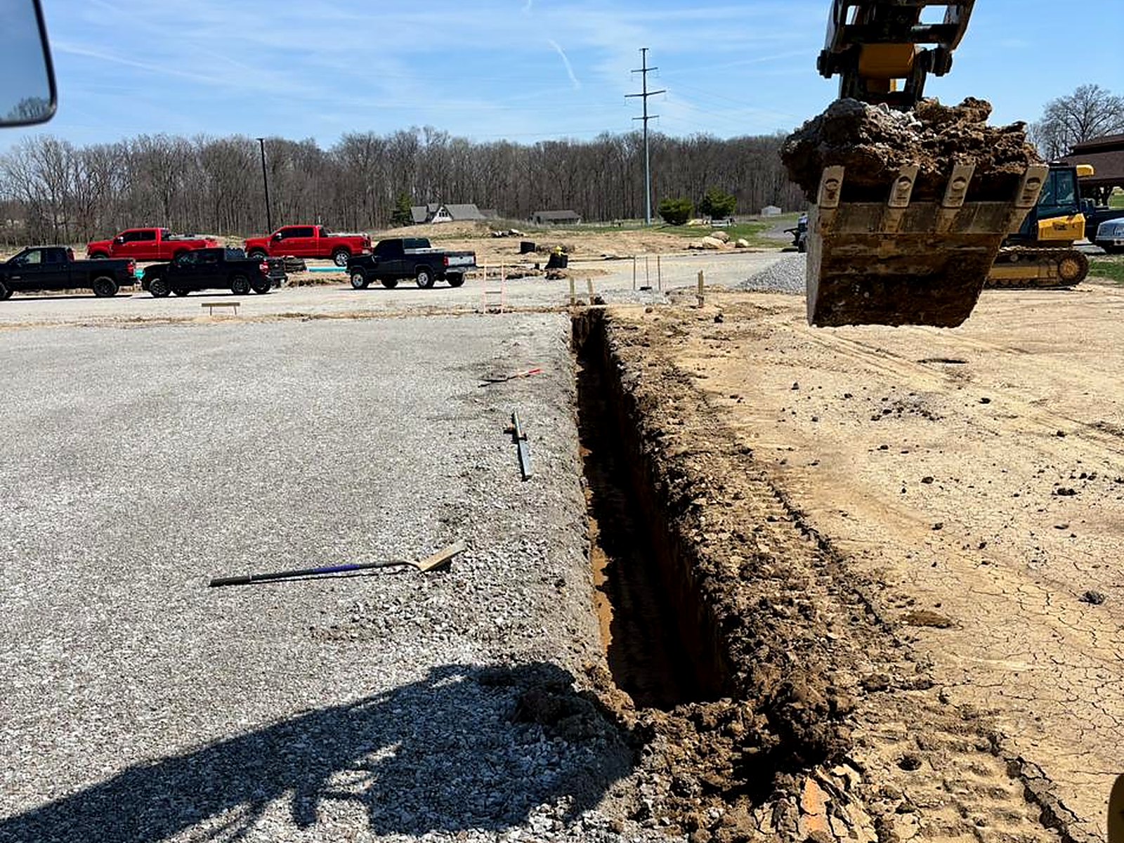 Excavation bucket over an open footing trench