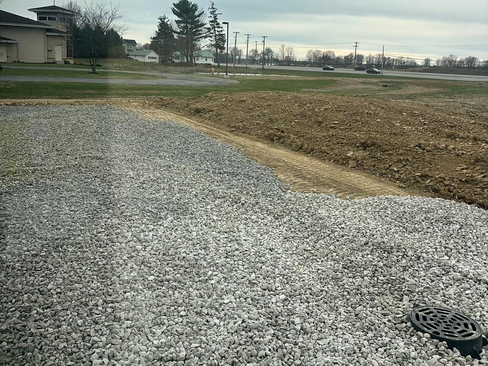 Compacted stone pad with drainage structure